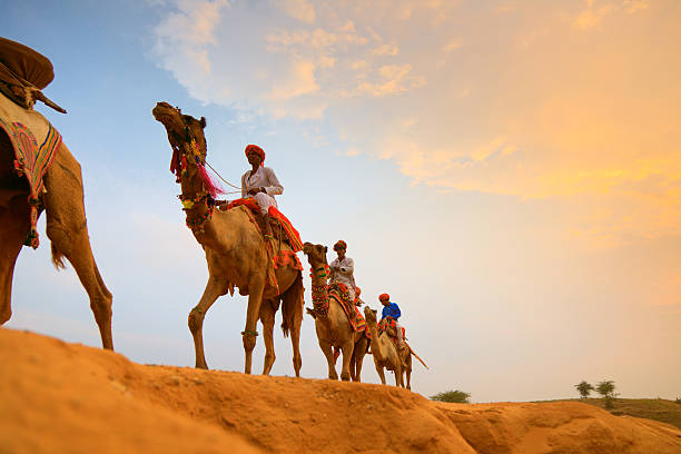 A tourist enjoying a camel ride safari in the golden sands near Jodhpur Bishnoi Village Safari Jodhpur.