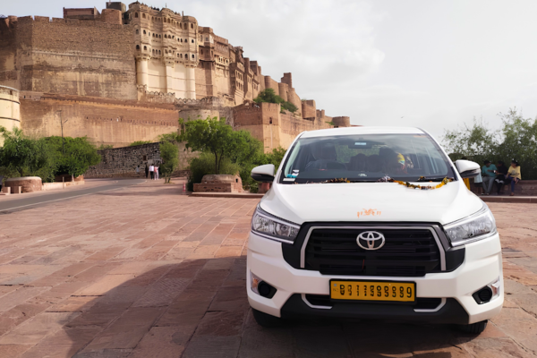 JCS Cab white Toyota Innova parked near Mehrangarh Fort providing Jodhpur taxi service.