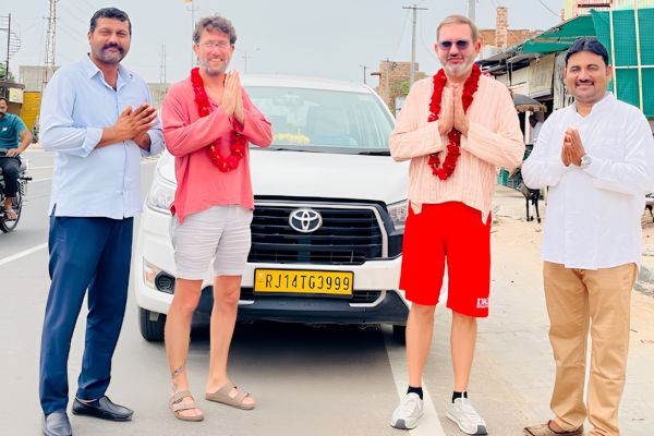 Tourists with local guides in front of a Toyota Innova in Rajasthan