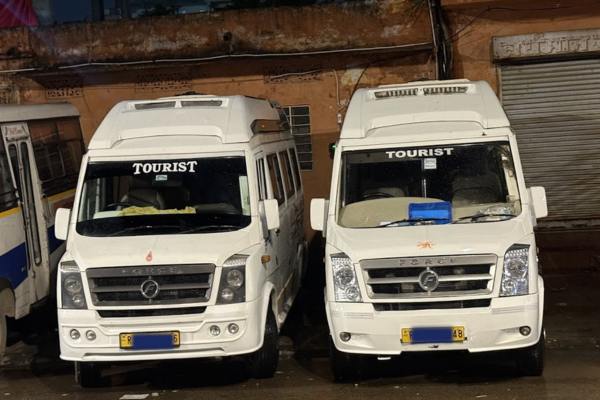 Two white Force Traveller tourist minibuses parked side by side, ready for group tours, sightseeing, and Rajasthan travel services.