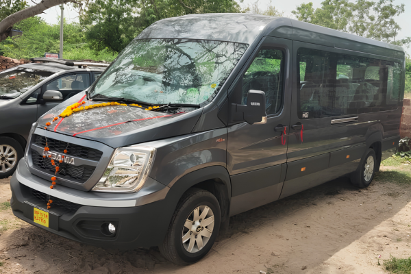 Grey Force Urbania luxury van parked outdoors, decorated for travel, offering premium group transportation and Rajasthan tour services.