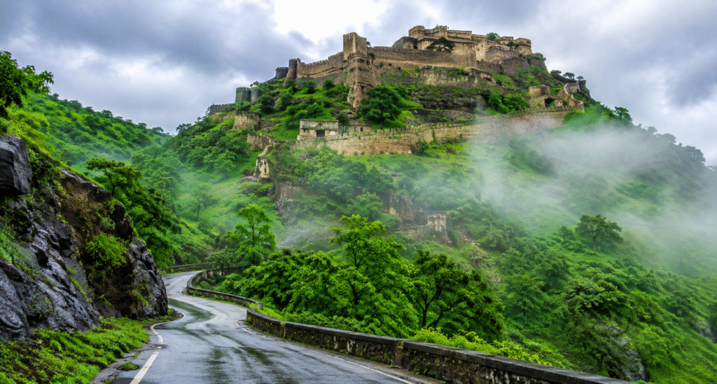Kumbhalgarh Fort surrounded by green hills and monsoon clouds in Rajasthan