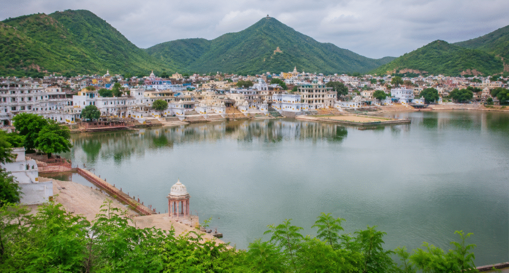 Pushkar Lake with temples and green Aravalli hills during monsoon season