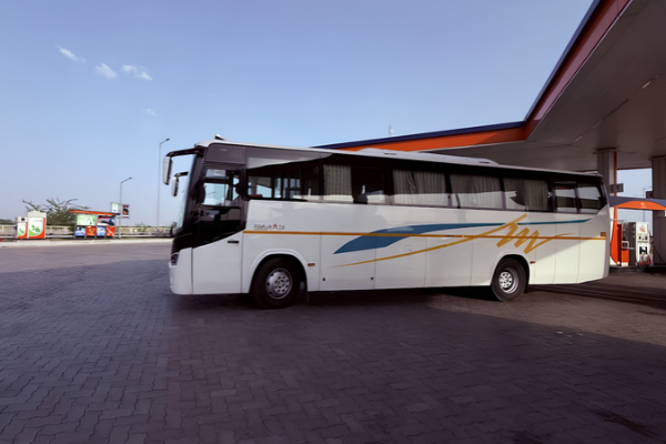 White luxury tourist bus parked at a fuel station.