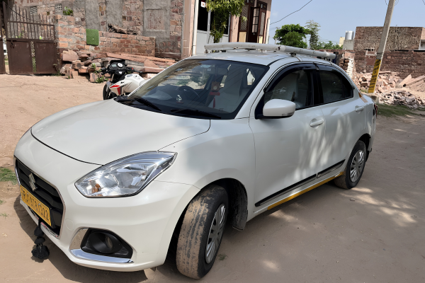 White Maruti Suzuki Dzire sedan taxi for comfortable city travel.