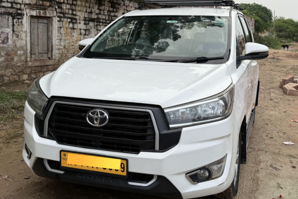 White Toyota Innova Crysta SUV taxi for premium family travel.