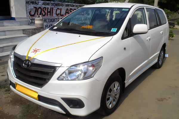 White Toyota Innova taxi for family trips and outstation travel.